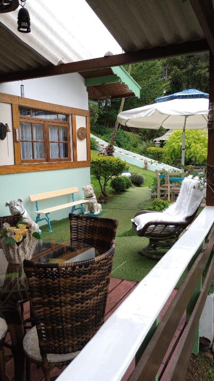 a patio with a table and chairs and an umbrella at Rancho da Raposa in Campos do Jordão