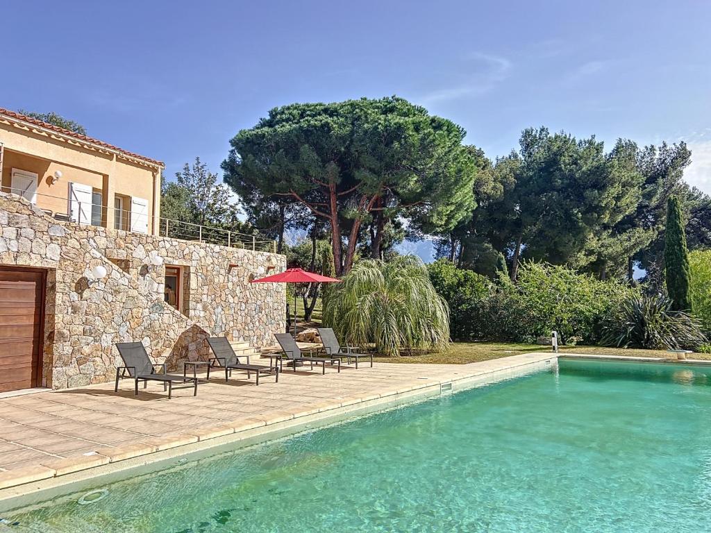 une piscine avec des chaises et une maison dans l'établissement Villa 13 oliviers Couchers de soleil LUMIO, à Lumio