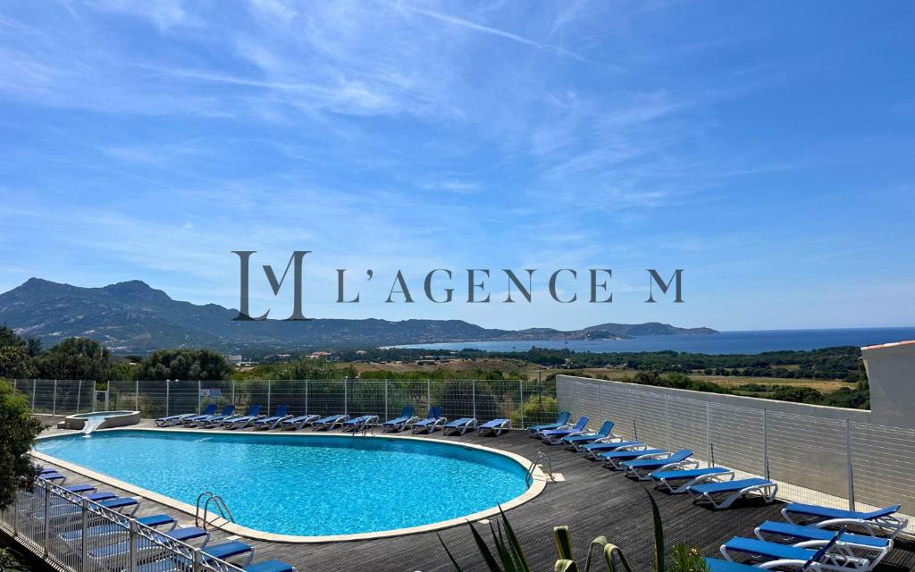 une piscine sur le toit d'un immeuble avec des chaises dans l'établissement Appartement Salduccio Piscine tennis mini golf LUMIO, à Lumio
