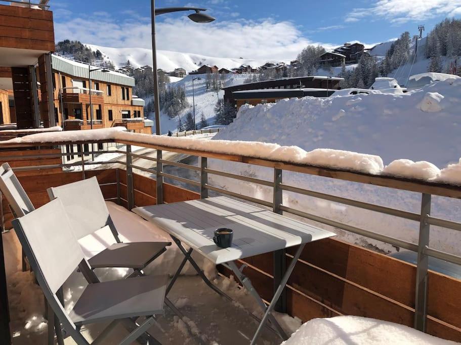 d'une table et d'une chaise sur un balcon enneigé. dans l'établissement Les Cristaux de La Plagne APPARTEMENT 8 personnes LODGES A505, à La Plagne Tarentaise