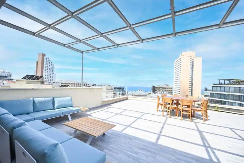 a living room with a couch and a table on a roof at Ben Yehuda Dream Penthouse in Tel Aviv