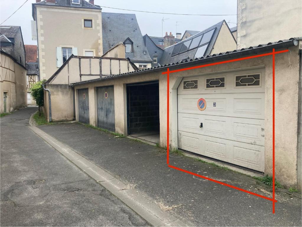 Deux portes de garage entourées de ruban adhésif orange dans une rue dans l'établissement Atypique et central, 4 personnes et garage privé, à Bourges