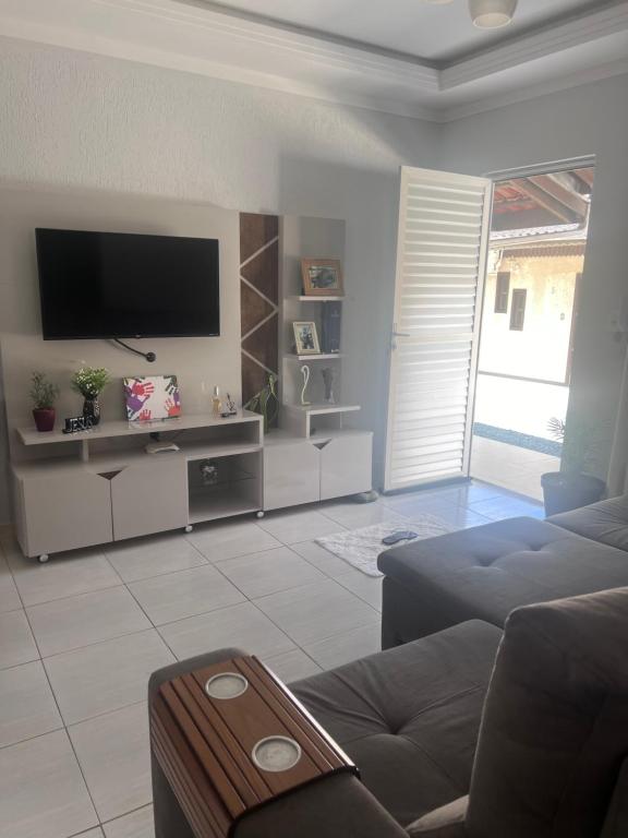 a living room with a couch and a flat screen tv at Recanto dos pássaros in Penha