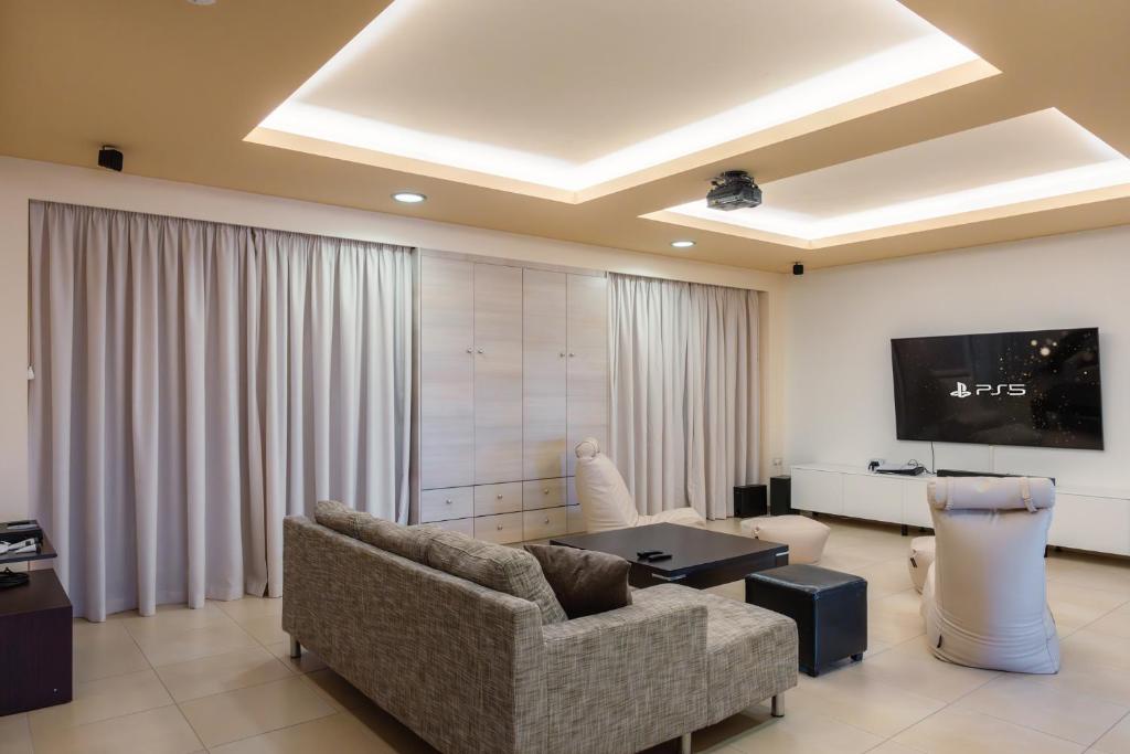 Televízia a/alebo spoločenská miestnosť v ubytovaní Elounda Panorama Villa