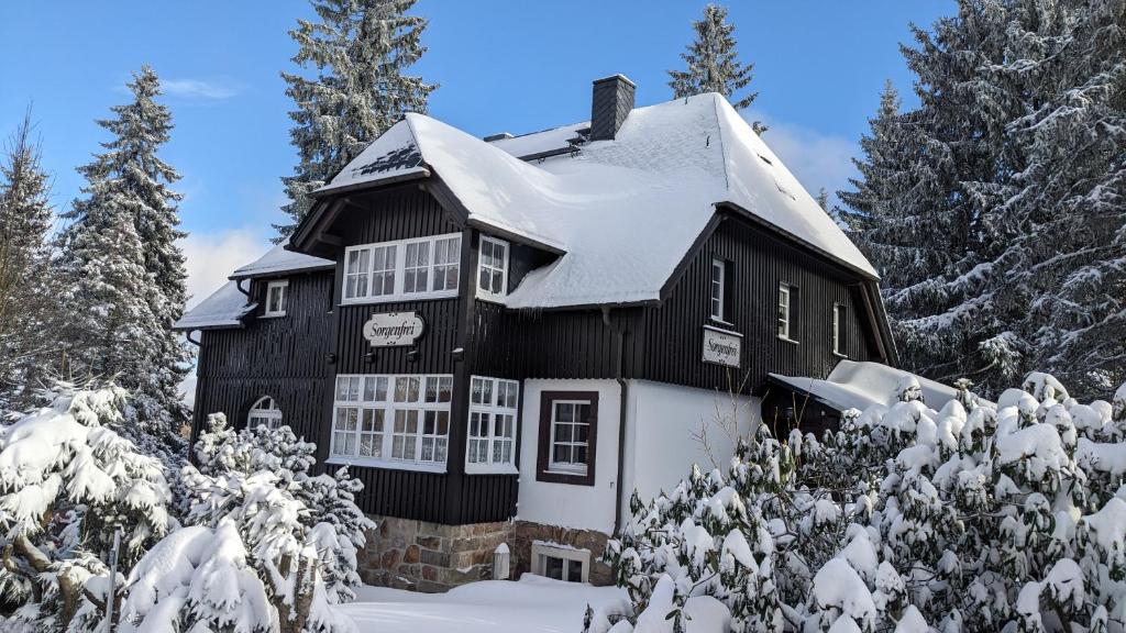 a black and white house in the snow at Ferienwohnung Sorgenfrei in Kurort Altenberg