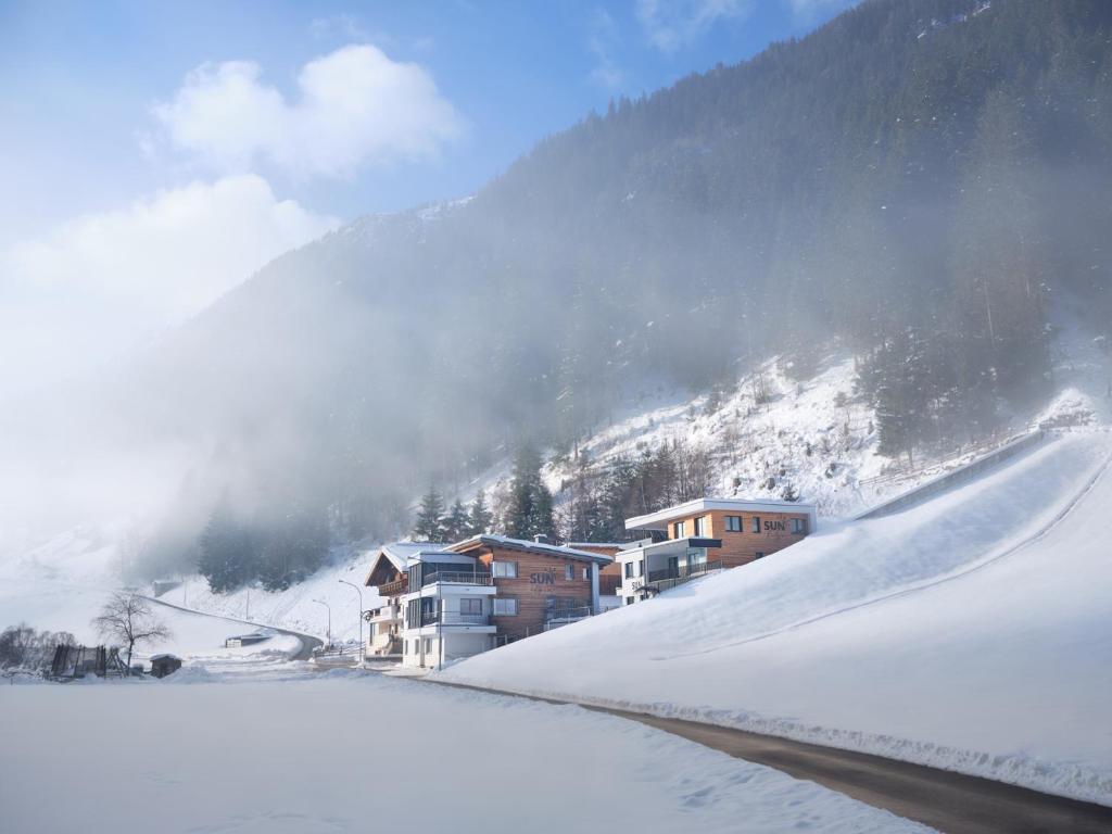 pokryta śniegiem góra z domami i stokiem narciarskim w obiekcie Sun Alpin w mieście Ischgl