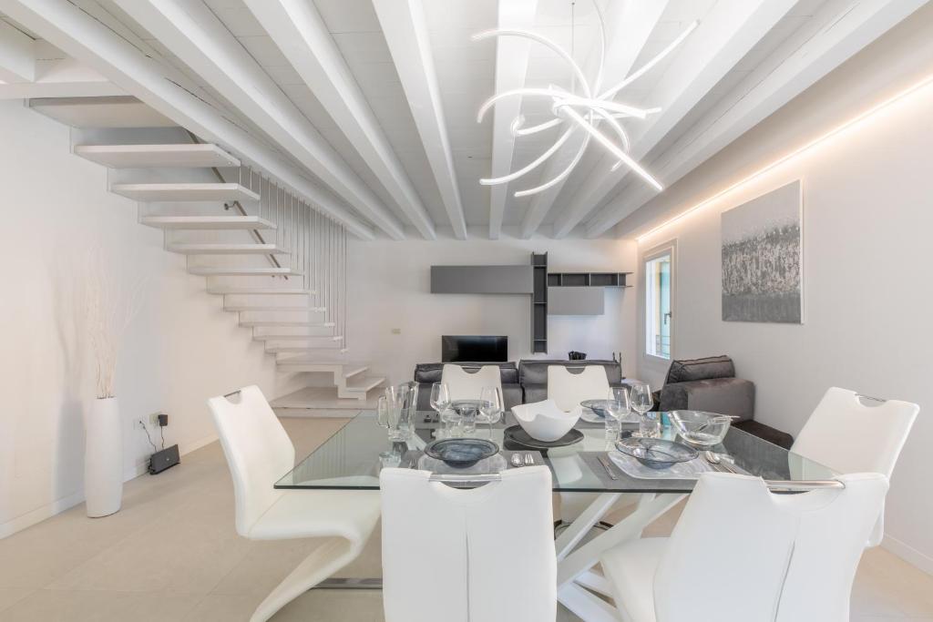a dining room with a table and white chairs at The White House - business and charme in Padova