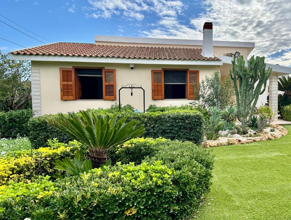 a house with a green yard with bushes at Garden Paradise near the sandy beach, parking & wifi in Marina dʼAvola