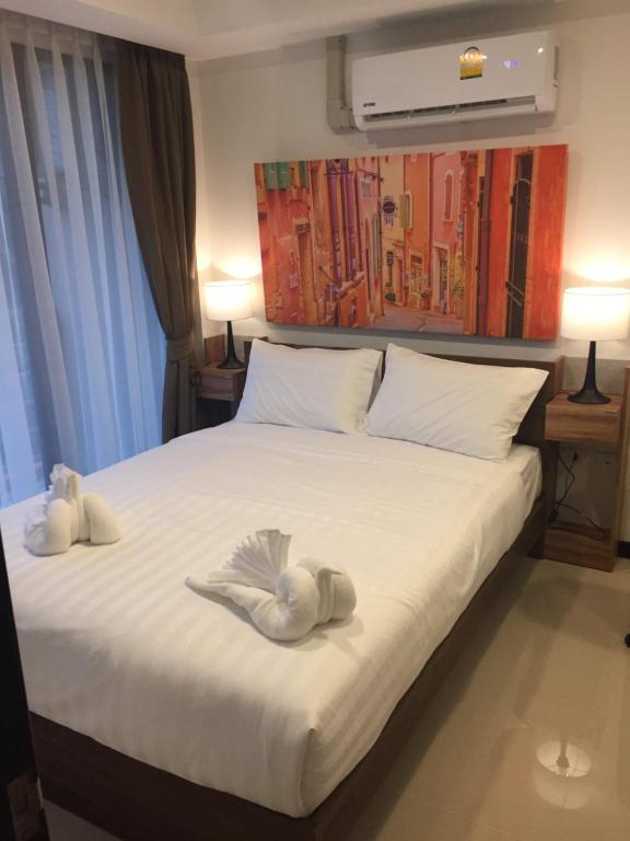 a bedroom with two swans towels on a bed at Mai Khao Beach Apartments in Mai Khao Beach