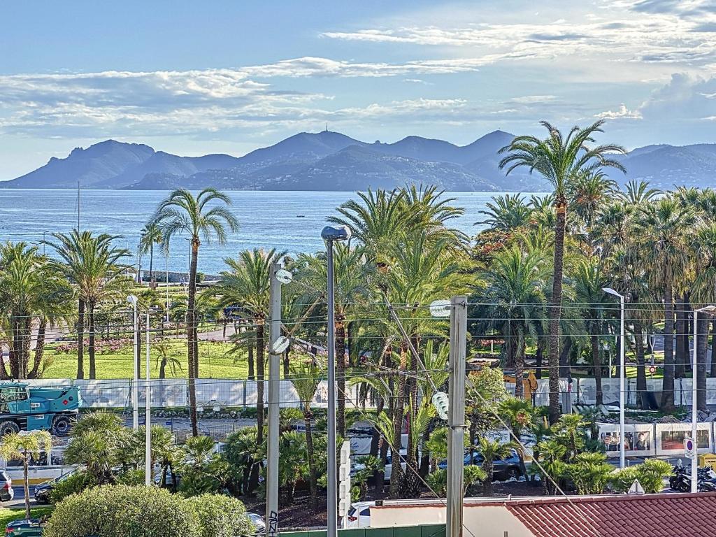 - une vue sur l'océan, les palmiers et un train dans l'établissement 78m2 Terrasse vue mer à 50m de la Croisette, à Cannes