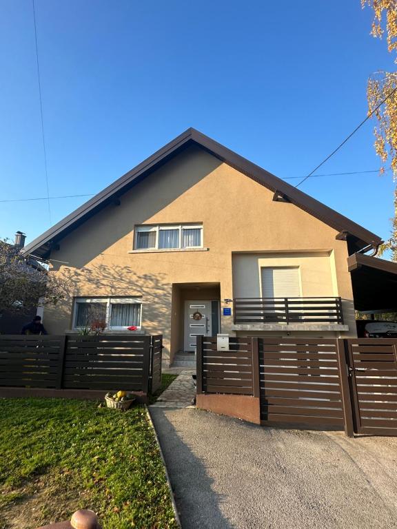 a house with a fence in front of it at Apartman Kopriva in Koprivnica