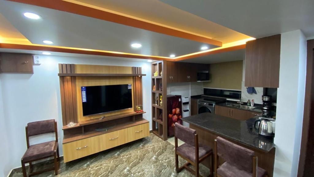 a kitchen with a television and a counter with chairs at Suite Stay in Kathmandu