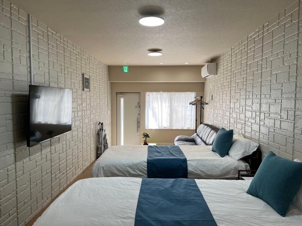 Postel nebo postele na pokoji v ubytování Comfy House Namba