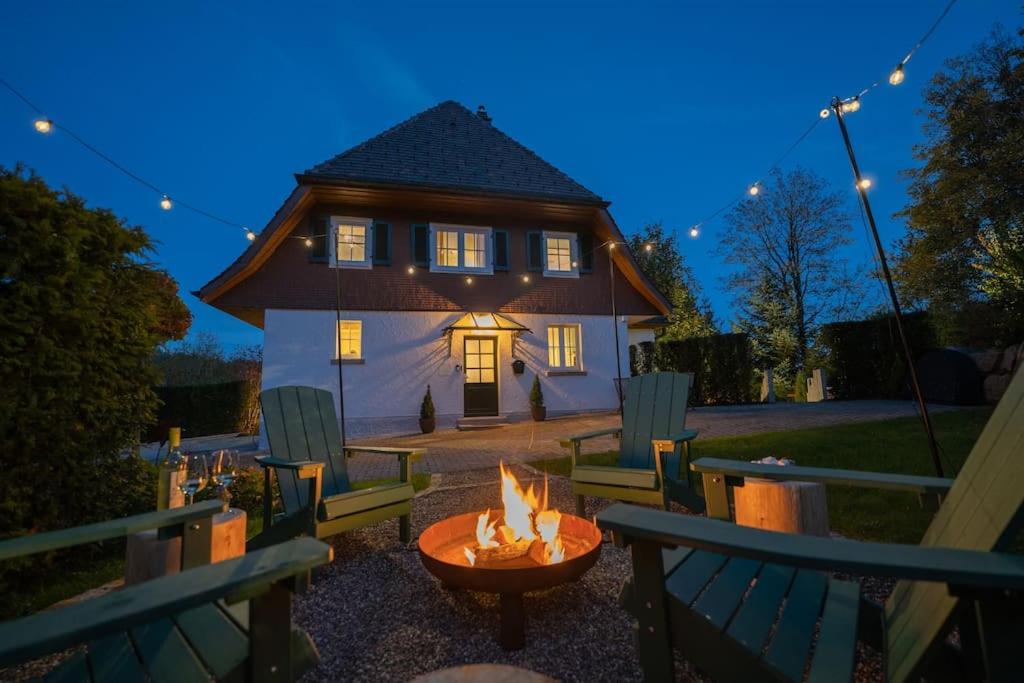 a fire pit in front of a house at night at Exklusives Ferienhaus am Waldrand mit Whirlpool und Sauna in Schonach