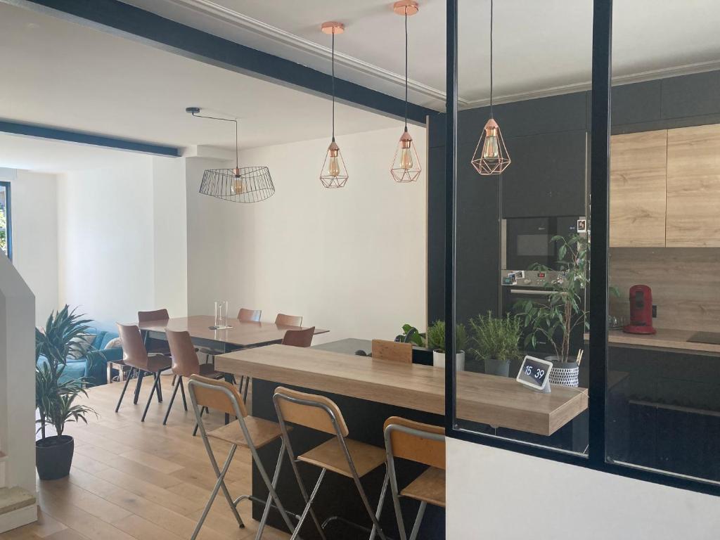 une cuisine et une salle à manger avec une table et des chaises dans l'établissement Maison avec jardin proche de Paris et du métro, à Montreuil