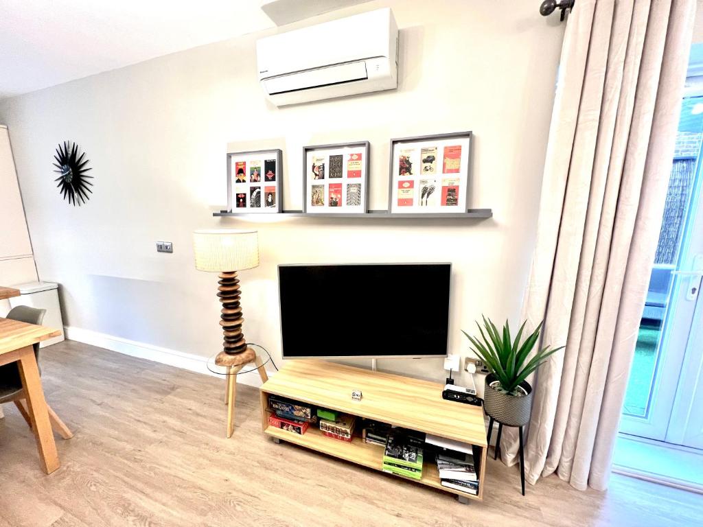 a living room with a flat screen tv at The Duplex Margate with Deck & Living Space Air Conditioning in Margate