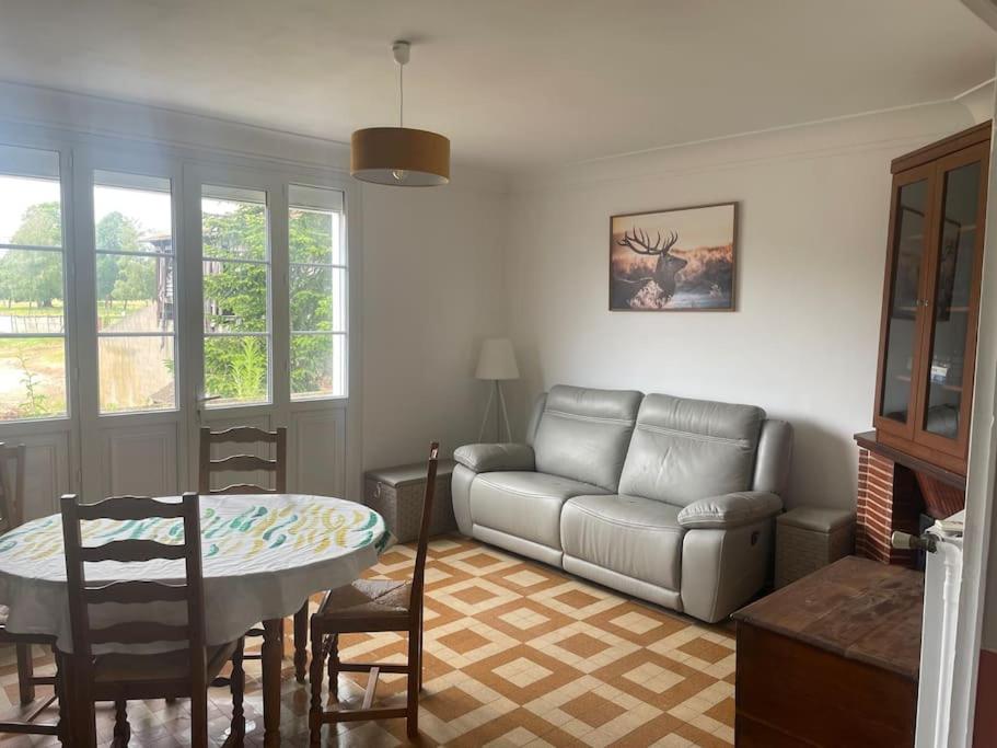 un salon avec un canapé et une table dans l'établissement Maison individuelle, à Dhuizon