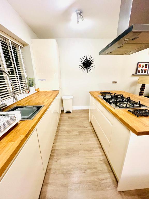 a kitchen with white cabinets and a stove top oven at The Duplex Margate with Deck & Living Space Air Conditioning in Margate
