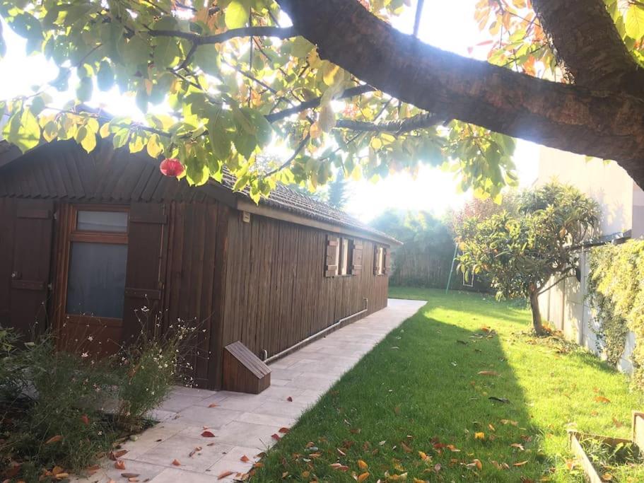 une maison avec une porte et une pelouse dans l'établissement À cabin on town, à Choisy-le-Roi