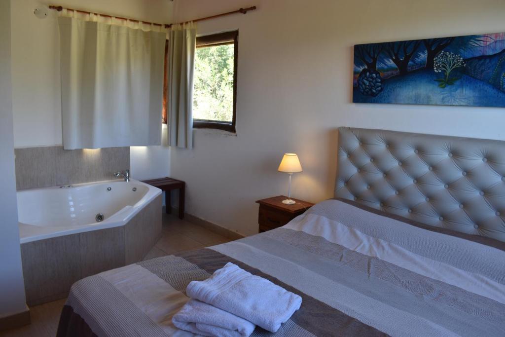 a bedroom with a bed and a bath tub and a tub at Campo de los Zorros in Nono