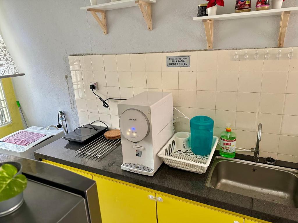 un bancone della cucina con frullatore e lavandino di De One Homestay Bayu Emas Near Beach a Batu Ferringhi