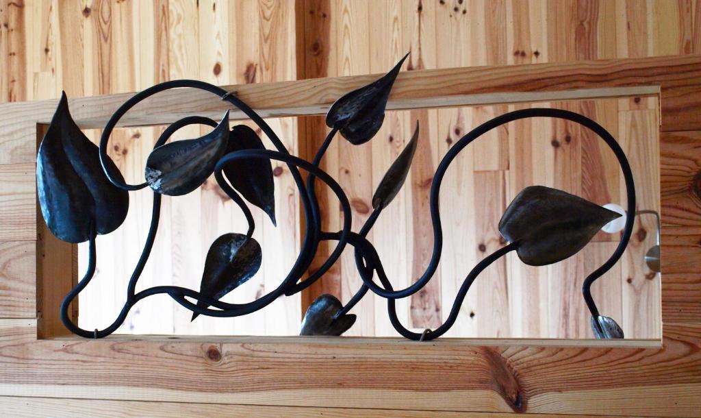 a black metal flower sculpture on a wooden wall at B&B Halen in Halen