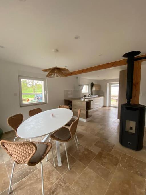 une cuisine avec une table, des chaises et une cuisinière dans l'établissement Maison dans un havre de paix, à Hartmannswiller