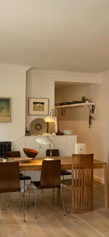 une salle à manger avec une table et des chaises en bois dans l'établissement Appartement à deux pas du canal Saint Martin, à Paris