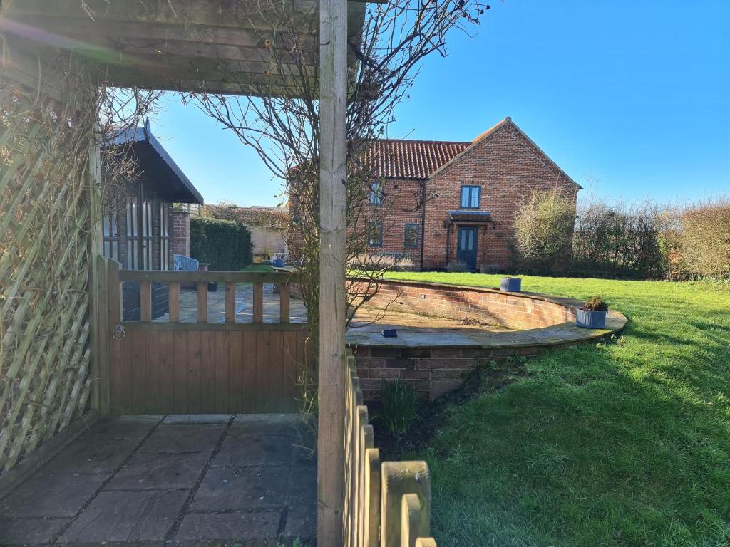einen Hinterhof mit einem Holzzaun und einem Pool in der Unterkunft Brisley North Norfolk cosy cottage garden pub and walks in Beetley