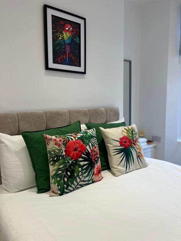 a bed with green and white pillows on it at 2025 Award Winner Liverpool Cherry House - 4 Bedrooms in Liverpool