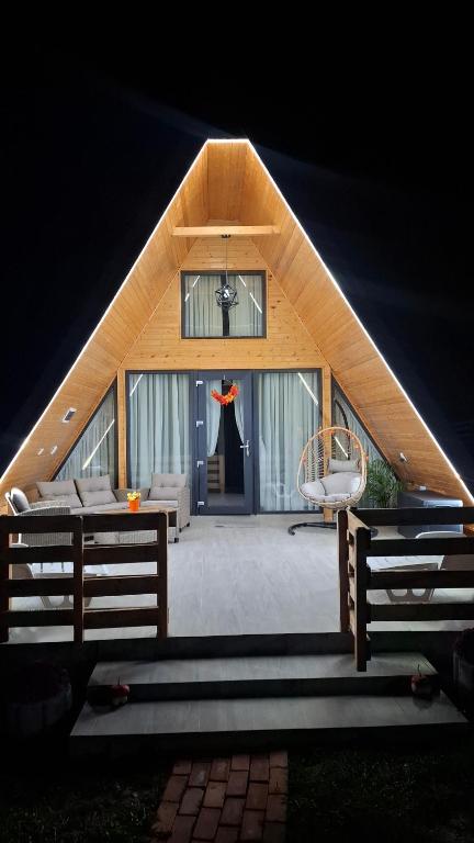 a house with a triangular roof with a window at Casuta de la ferma in Băiculeşti