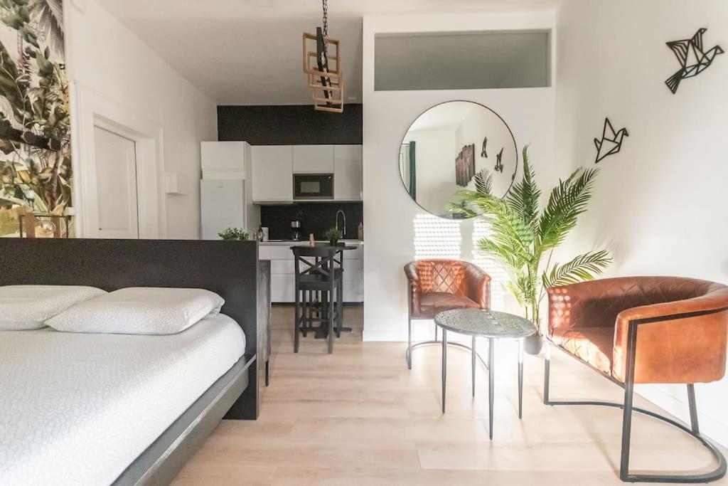 une chambre avec un lit, une table et des chaises dans l'établissement L'Exotique - Hypercentre - Gare, à Angers