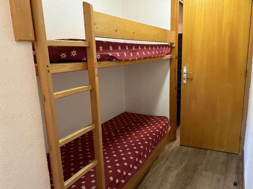 - deux lits superposés dans une chambre avec une porte dans l'établissement Studio 2/4 pers, Accès Pistes et Piscine, Proche Commerces, Méribel - FR-1-180-297, à Méribel