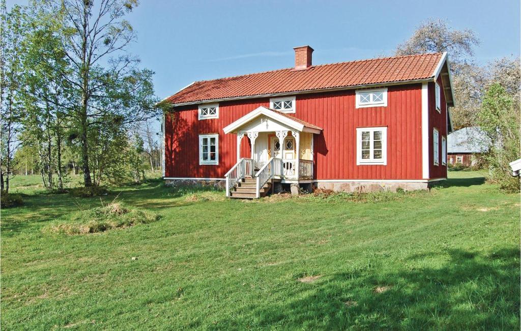 a red barn on a field with a grassy yard at One-Bedroom Holiday Home In Habo in Habo