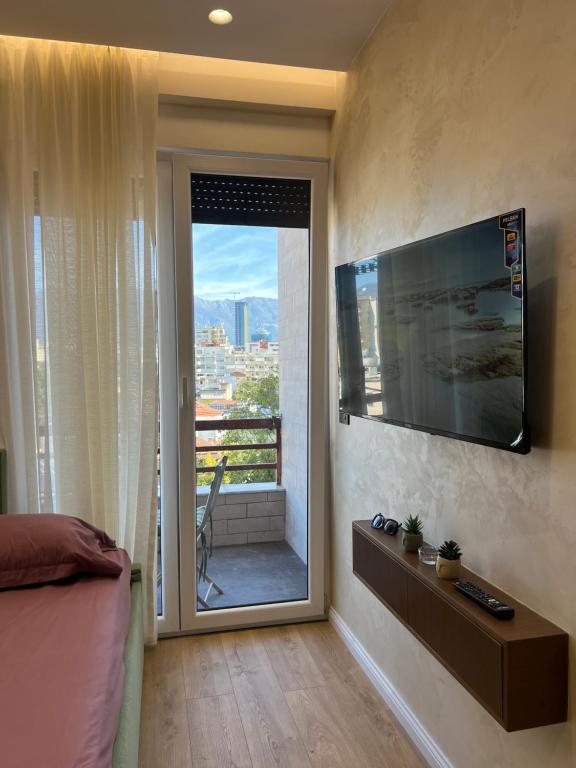 a bedroom with a sliding glass door to a balcony at City Center Urban Condo in Tirana