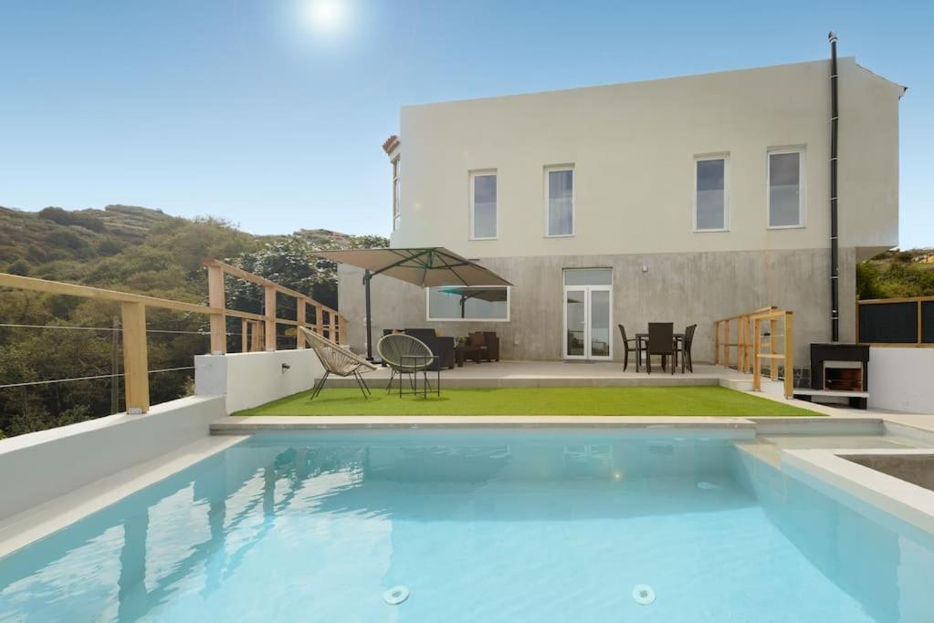 a swimming pool in front of a house at Villa con piscina y vista al mar in Moya