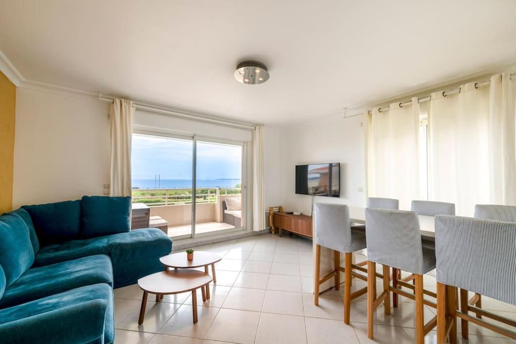 un salon avec un canapé et une table avec des chaises dans l'établissement Modern Beachfront family apartment with pool, à Antibes