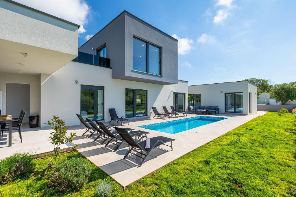 a villa with a swimming pool and lawn at Villa Vivre in Ližnjan