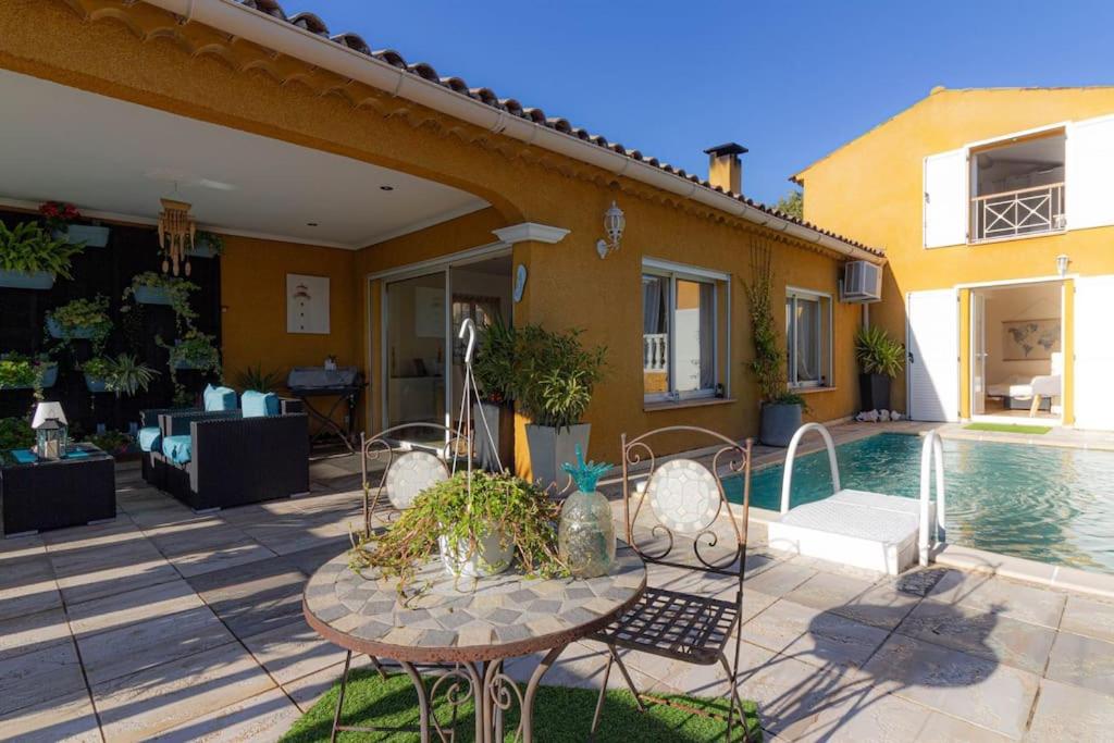 a patio with a table and chairs next to a house at Charmante Maison de village- les adrets in Les Adrets de l'Esterel
