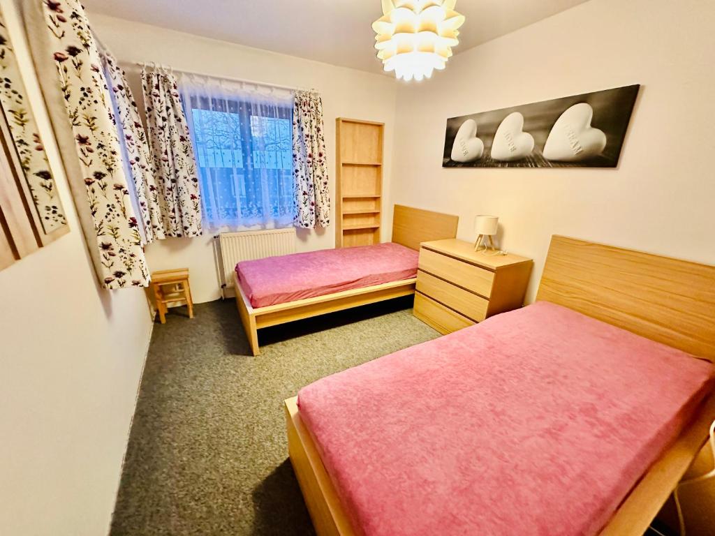 sypialnia z 2 łóżkami i żyrandolem w obiekcie Pension Lenka 2 w mieście Harrachov