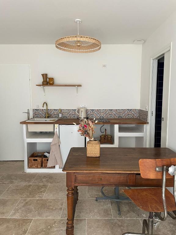 une cuisine avec une table en bois et un comptoir dans l'établissement Studio à deux pas des Calanques, à La Ciotat