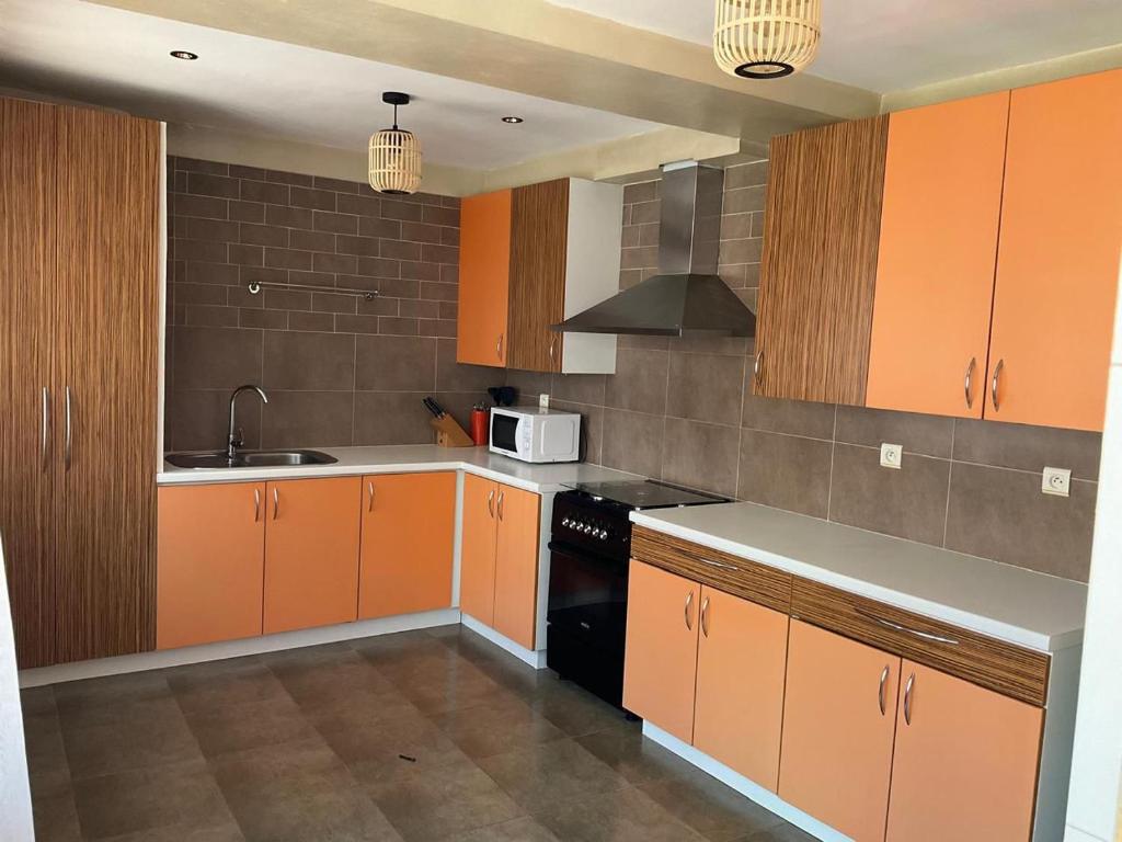 a kitchen with orange cabinets and a black appliance at Kokoloko in Isoraka