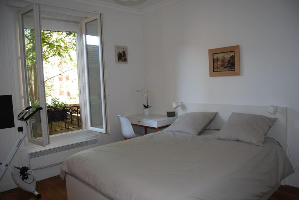 une chambre blanche avec un lit et une fenêtre dans l'établissement Appartement 40 m2 à, Boulogne Billancourt, à Boulogne-Billancourt