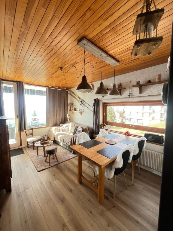 un salon avec une table et un canapé dans l'établissement Appartement charmant - Chamrousse - 36 m² - Vue montagne, à Chamrousse