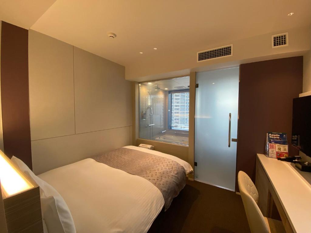 Postel nebo postele na pokoji v ubytování APA Hotel Keikyukamata Ekimae
