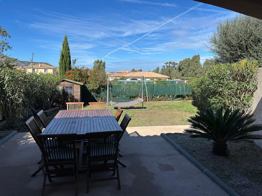 - une table et des chaises dans une cour avec une aire de jeux dans l'établissement Maison Calenzana, à Calenzana