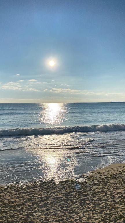 - une plage au soleil réfléchissant sur l'eau dans l'établissement Studio plein de charme, à Les Sables-dʼOlonne