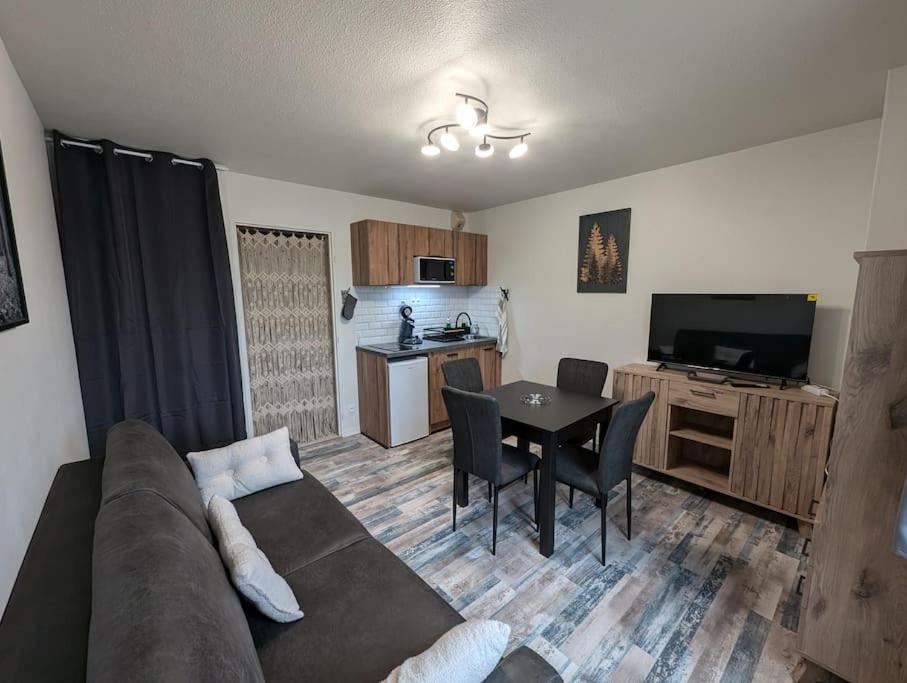 un salon avec un canapé et une table dans l'établissement Chez Paulette, Studio cosy au centre ville de Gérardmer, à Gérardmer