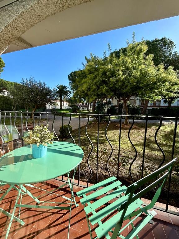 une table et des chaises en verre sur une terrasse avec une clôture dans l'établissement El Galion, piscine, plage, terrain tennis, à Argelès-sur-Mer