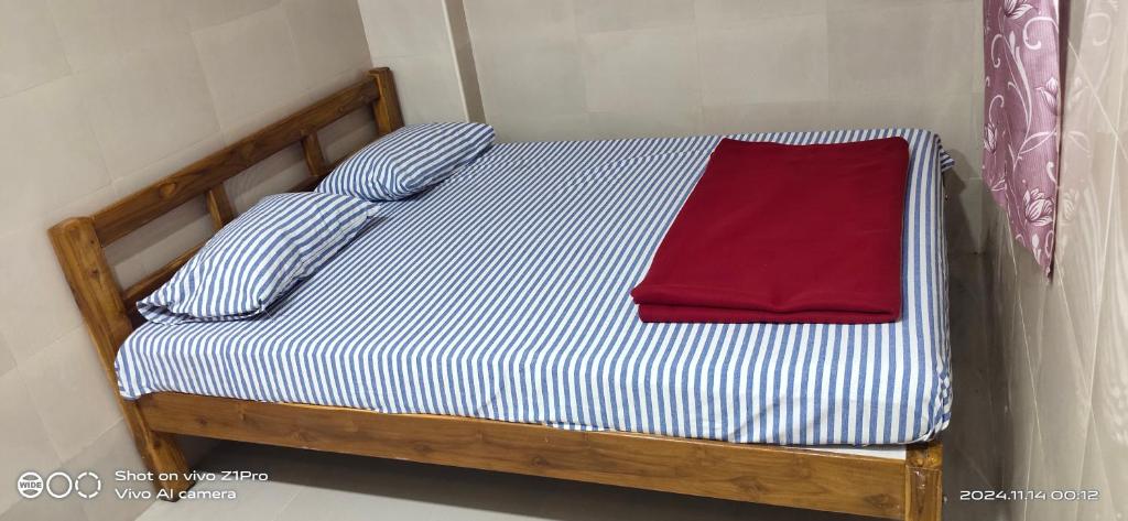 un lit avec des draps rayés bleus et blancs et deux oreillers dans l'établissement Shree chendur Residency, à Tiruvannāmalai